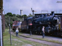 An extra train has been called at the CPR, former GRR/LE&N, shops in Preston on July 13, 1964, to deliver CPR D-10-g 4-6-0 894 (Angus Shops, 1911) to its new home at the Doone Heritage Village at the South end of Kitchener.  The hogger in the 6707 is seen waiting on the crew to finish looking over the 894 and van 435832 before getting underway to the CNR/CPR interchange just to the North of Queen Street South and Homewood Avenue (behind the <a href=http://www.railpictures.ca/?attachment_id=23222>now closed Nougat Bakery</a>).  Formerly home to the Lake Erie & Northern and Grand River Railway Equipment, the <a href=http://www.railpictures.ca/?attachment_id=10413>Preston Shops,</a> built in 1907, would serve into the 1960's as a locomotive shop for the SW1200RS units now working the line.  Eventually, the Preston based jobs would be moved to Galt, reducing Preston to a <a href=http://www.railpictures.ca/?attachment_id=31973>car shop</a> until a fire destroyed the building in April, 1992.  The "Grand River Railways Shop" sign still survives today on the <a href=https://live.staticflickr.com/65535/48787517857_95f38e1568_b.jpg>East end of Barn 2</a> at the Halton County Radial Railway.