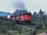 CN train 214 heads east out of Capreol, Ontario on the now abandoned Alderdale Subdivision with an all MLW power consist: 2534-2519-2500 and 74 loads 3 empties 5585 tons.  The train is shown approaching the Ella Lake road crossing.   