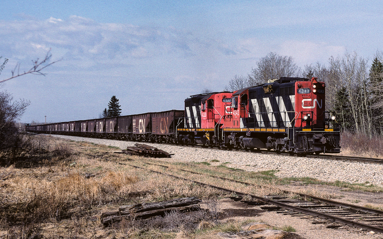The 4343, in just a few more car lengths, will leave the Coronado Sub. and take the connecting track to the Lac La Biche Sub. It will continue north with the 25+ ballast hoppers to the point where the line re-hab work is being done. The track in the foreground is the Kerensky siding. Quite often during the summer months it is stuffed with various types of track equipment etc.