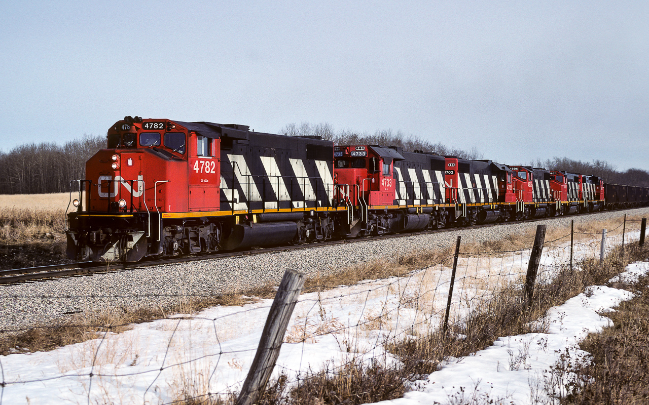 A train of approx. 30 sulphur empties is approaching the connecting track at Kerensky. The consist is made up of deadhead units. Only the 4782, 4733 and 4702 were throttled up. The 4806, 4807 and 4803 were just idling as they went by. To match the extra units, an extra caboose 79624 was with the 79675 on the tailend. Both trains will return in about 24 hours time, each bringing 50 loads home. Of note, the 4733 was a rare visitor on the Coronado Sub.