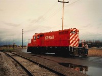 The TH&B "Day Port" running CPR Power, ex TH&B #74 now in CP Action Red as 1684  has just made a 2 car drop at the International Nickel (INCO) Refinery.  The train is crossing Durham St. at Reuter Road. In the background on the right is Port Colborne Drop Forge (sad note PC Drop Forge sister plant Welland Forge was permanently closed on Monday Oct. 26th, 2020 after 55 years of operation).  The view is looking east and the locomotive is about to enter back onto the former Dunnville Subdivision tracks that were dead ended just east of here 2 years earlier.  The crew would pick up their TH&B caboose before switching other industries in town.  