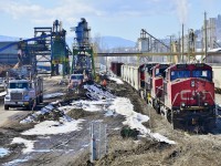 An industrial scene in Lavington BC. On the left is the Tolko Planer mill and on the right the Pinnacle Pellet plant. Three units are preparing to assemble today's train that will head west to Vernon and then north to Kamloops.