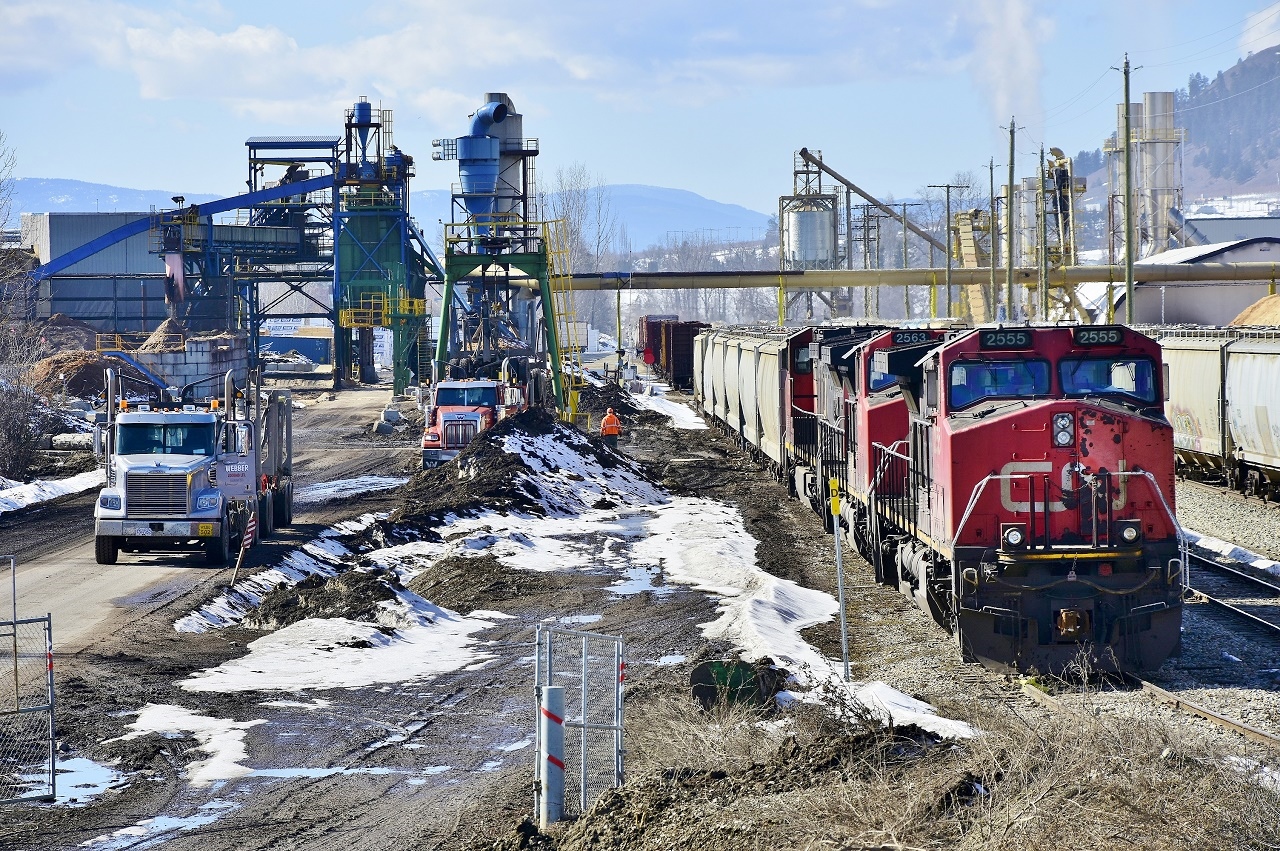 An industrial scene in Lavington BC. On the left is the Tolko Planer mill and on the right the Pinnacle Pellet plant. Three units are preparing to assemble today's train that will head west to Vernon and then north to Kamloops.