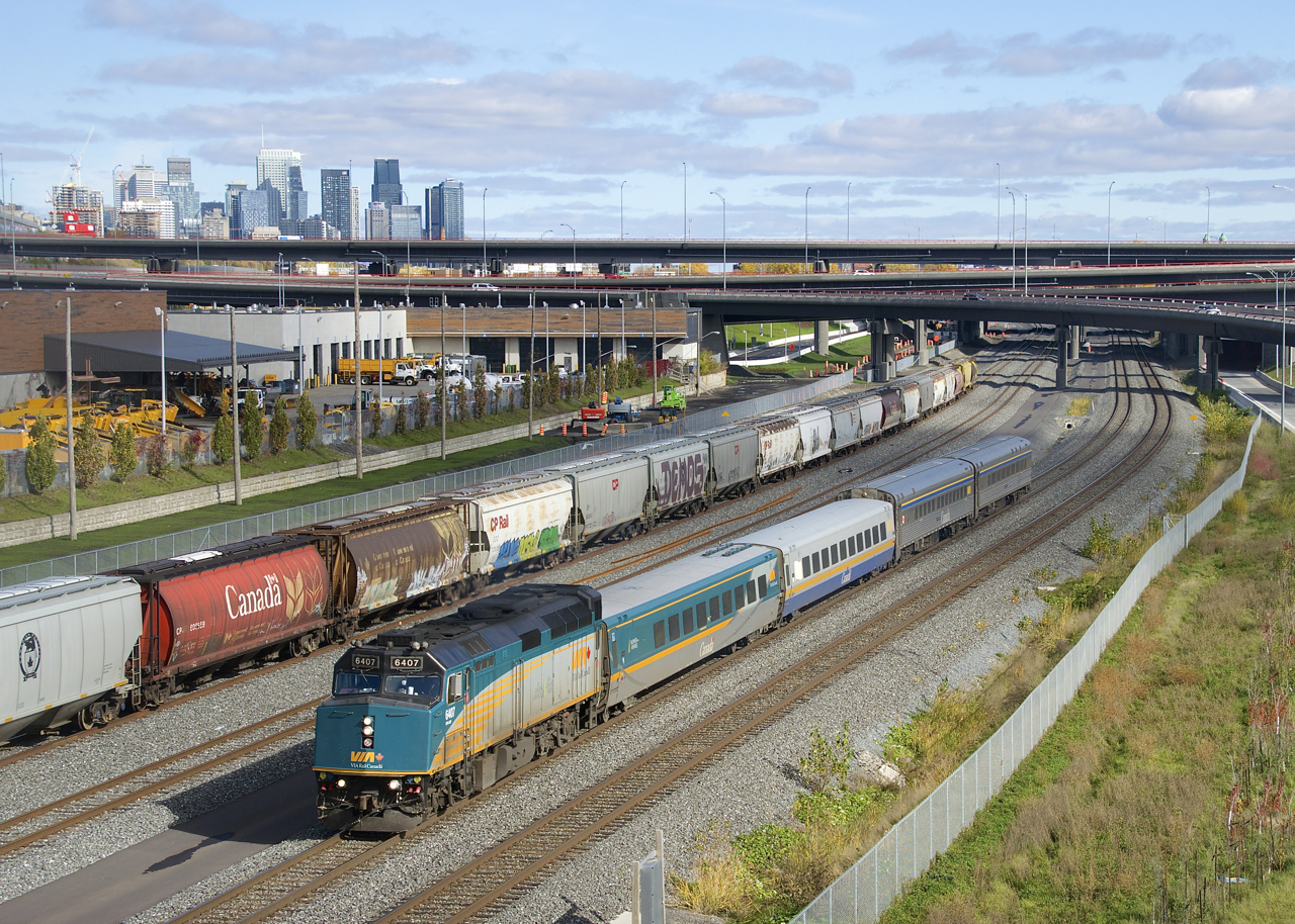 The rebuilding of the Turcot interchange and nearby roads and highway on and off-ramps is just about complete (part of the interchange is visible in the background) and that includes this overpass over CN's Montreal Sub, which opened just last week. Here VIA 35 with VIA 6407 and a mixed LRC/HEP consist passes some grain cars. Visible at far left is the skyline of downtown Montreal.