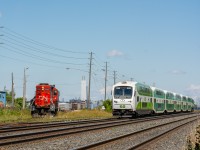 A westbound lakeshore west GO train flies through the west Oakville yard ladder where CN 7080 and another GP9RM are long-hood-forward awaiting the GOs passage in order to depart the yard and head for a short trip to Aldershot.