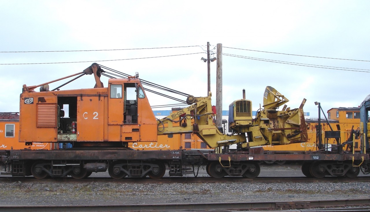 Ready and waiting for the first big snowfall of winter 2007/2008 is QCM C2 113-002 3531, a Wellman model DE 600 locomotive crane, serial number 4385, built in 1959. Instead of the traditional lattice type boom used for hoisting, magnet, and clam bucket work, the unit is outfitted with a Rolba Snowblast snow blower attachment QCM 161-025 3540. I captured the combined machines sitting at the QCM shops in Port Cartier, QC during an October 30, 2007 visit to the railways office and shop complex.