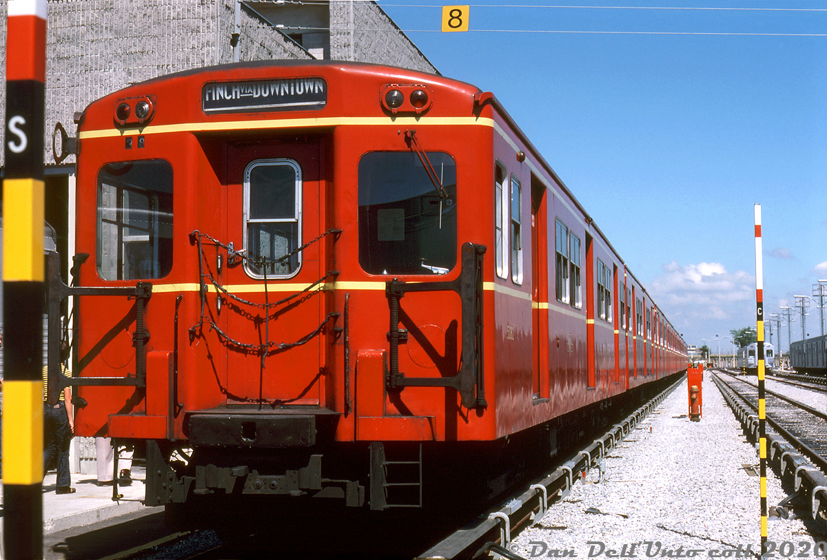 Despite their age, the 1950's-built Gloucester "Red Rocket" subway cars still looked great years later. An 8-car train of TTC "G" cars, lead by G1 5082, sits parked inside the new Wilson Subway Yard next to the maintenance shop buildings. Note the Identra Coil mounted on the upper right of the lead car (used to activate "next train" destination boxes on station platforms) as well as the left-side mounted operators controls - all later car models including the M1's, H1's and so on would come with operators controls mounted on the right side. The last of the G's were retired in the early 90's, with cars 5098-5099 preserved at the Halton County Radial Railway museum.  This scene was photographed during a tour of the shops as part of a weekend fantrip during July 1st-2nd 1978. A new pair of Hawker Siddeley H5 cars are visible parked in the distance, part of an order purchased for the new Spadina line extension that opened earlier that year.  Photographer unknown, Dan Dell'Unto collection slide.