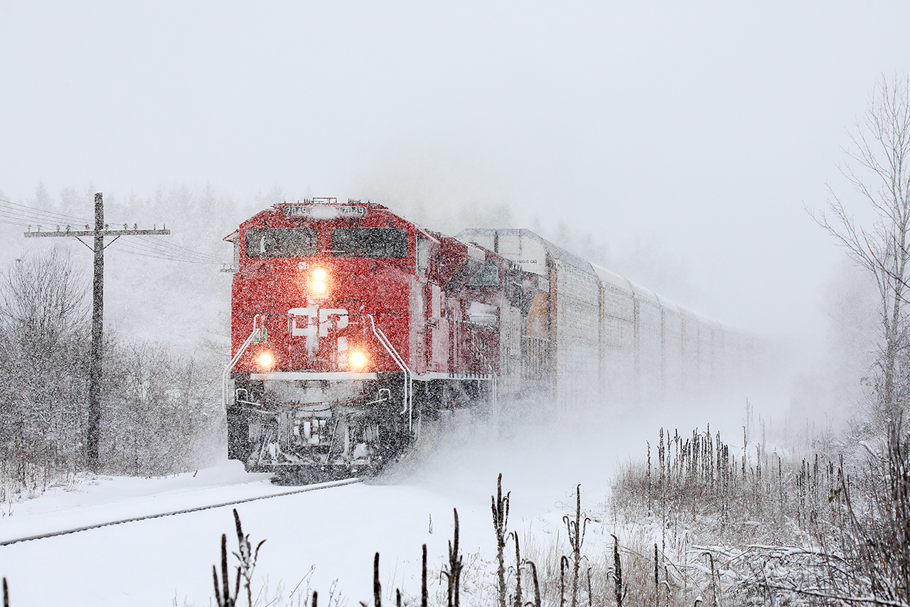 It's been snowing for about 3 hours. The roads are covered in 3 inches of slush, and no one remembers how to drive in winter conditions. The railroad doesn't care. 241 (9731 trailing) doing every bit of "mile a minute" races west in conditions that making railroading the chosen form of transport. It's a good day.