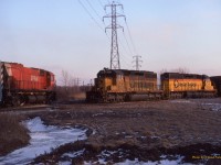 Question. What Canadian Shortline hosted trains from CP, C&O/CSX, DT&I, Conrail, N&W/NS and GTW? The Essex Terminal Railway in Windsor. Here we see a CP transfer job heading East along the Essex Terminal towards Dougall Ave where it will then make a reverse move to shove into the Conrail interchange (adjacent to the Electric Yard). What is unusual this day is the use of an M-630 as these moves usually were handled by SW yard switchers or GP9's. Once the CP is clear, No 942 will pull onto the Essex Terminal and pull across Tecumseh road and then down a connecting track into CP Windsor Yard.  The "Loop Track" from the tunnel was also used by the DT&I whilst the GTW interchanged with ETR closer to Dougall Ave.  After the CN takeover at the CASO, the Conrail and N&W/NS pullers would use the Loop track to access CP Windsor Yard. The DT&I/GTW would go into VanDeWater Yard. Today the Loop Track has been removed.   