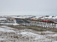 Q 10251 21 soars across the Battle River Trestle in Fabyan, Alberta with CN 3039 on the point and CN 8821 in the middle of their 164 car train.  The Battle River Trestle stands 195ft above the valley floor and is an impressive 2775ft long.  

