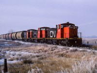 With his arm stretched out, the hoghead is in the midst of rule 14l as 584 approaches a crossing west of Redwater. This was a very cool day, which seems appropriate for a Friday the 13th. You can see in the middle of the train a couple of the early style hoppers. Often wondered if there was a customer that requested them as they were frequently a part of the consist.