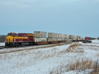 CN 3069, sporting Wisconsin Central colours, leads Chicago to Vancouver train Q 11791 21 through Chauvin, Alberta in the last light of a busy day on the Wainwright Sub.