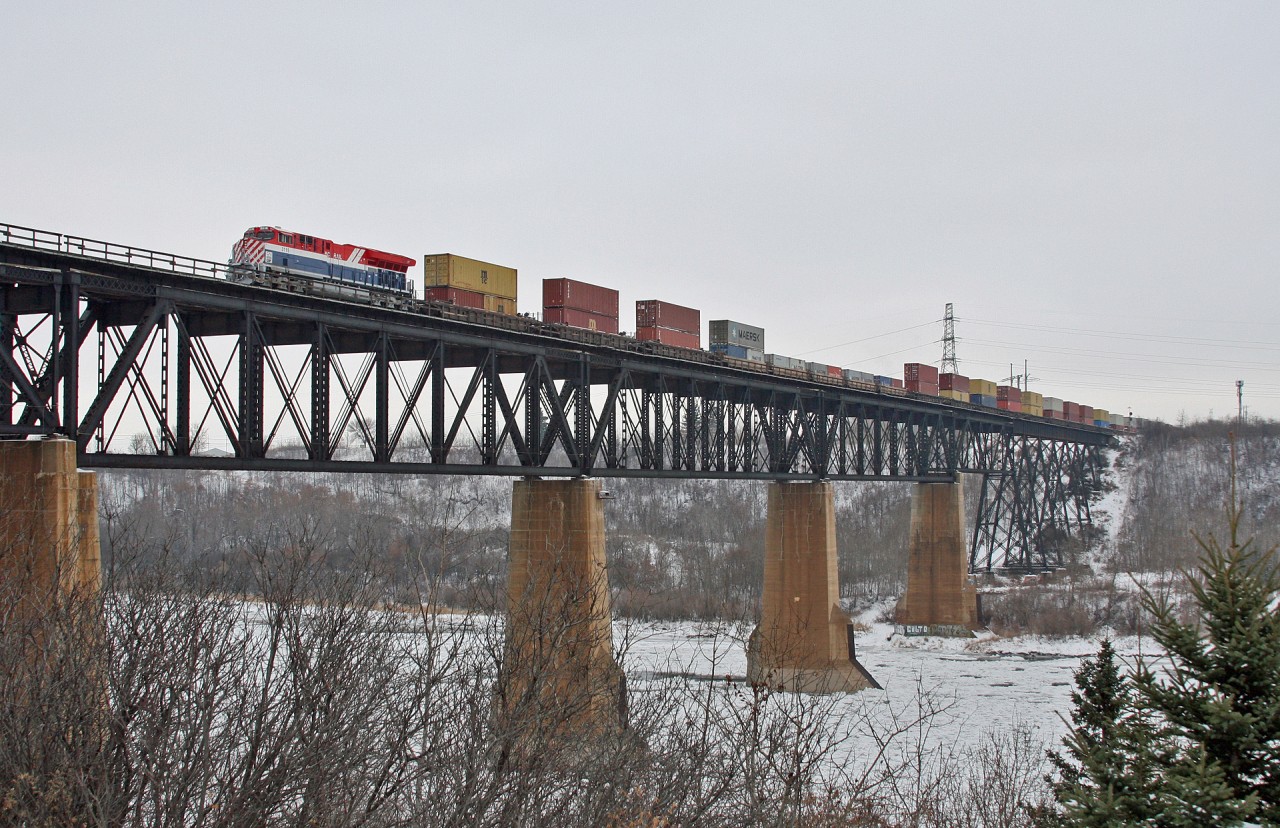 CN 3115, the BC Rail heritage locomotive soars across the North Saskatchewan River and into Edmonton, Alberta, with train Q 18331 20 in tow. Upon arrival at Walker Yard, the 3115 and mid-train remote CN 3818 will be fueled, while a quick crew change is performed.  Within the hour, Q 183 will depart for Prince Rupert, British Columbia with 143 intermodal cars for the port.  While not operating on former BC Rail territory, the locomotive will be making its first appearance in it's namesake province.