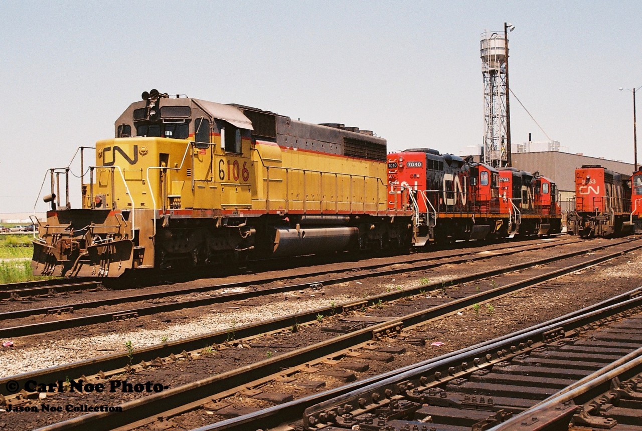 During 1994, CN had acquired 24 SD40-2’s from Union Pacific, that were originally numbered UP 4090-4102, B4103, 4104, 4106-4114. CN quickly temporarily renumbered them by changing the first number to a ‘6 from 4’ to cycle them into service. These units were seen all over the CN network that year and you would usually see at least one or two roll by during a full day trackside. Eventually they became CN 5364-5387 by late 1994 and through 1995 after being remanufactured at AMF in Montreal.

Here CN 6106 is viewed along with GP9RM’s 7040 and 7033 at the MacMillan yard diesel shop during a late summer morning. CN 6106 would later become CN 5373 in November 1995.