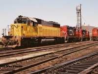 During 1994, CN had acquired 24 SD40-2’s from Union Pacific, that were originally numbered UP 4090-4102, B4103, 4104, 4106-4114. CN quickly temporarily renumbered them by changing the first number to a ‘6 from 4’ to cycle them into service. These units were seen all over the CN network that year and you would usually see at least one or two roll by during a full day trackside. Eventually they became CN 5364-5387 by late 1994 and through 1995 after being remanufactured at AMF in Montreal.
<br>
Here CN 6106 is viewed along with GP9RM’s 7040 and 7033 at the MacMillan yard diesel shop during a late summer morning. CN 6106 would later become CN 5373 in November 1995. 
