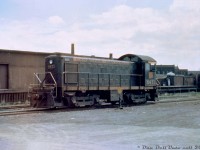 It's 1955 and steam still roamed the Canadian National system, but the latest and greatest in switching power, CN 8471 (an MLW S3 built in 1953) idles on the service track next to the Parkdale freight shed behind CN's Parkdale Station, just south of the <a href=http://www.railpictures.ca/?attachment_id=36087><b>Queen Street underpass</b></a>. The two tracks north of the switcher were for spotting cars alongside the freight shed. The boxcars in the background are spotted on the two the team tracks by the freight shed. Visible in the background to the right is part of the old American-Abell agricultural manufacturing factory built in 1885 (that later became home to a plate steel manufacturer, then lofts, and eventually demolished 2011 for redevelopment. The nearby Abell Street is a reminder). The freight shed itself became home to a fruit market in later years, and the last remnants were demolished in 2007/08 for the extension of Sudbury Street.<br><br>CN and CP both had stations at Parkdale, and even though CP was more well-know in the area for its <a href=http://www.railpictures.ca/?attachment_id=35550><b>sprawling Parkdale Yard</b></a> facilities located on the south side of the rail corridor, CN had a sizable number of industries along the north side of their Brampton (later Weston) Sub to keep their own switchers busy, including the Massey Ferguson lead that ran as streetrunning up Sudbury Street to access the factories north of King Street. Massey Ferguson also had sidings for their buildings on the south side of King around Strachan Ave. And further south were <a href=http://www.railpictures.ca/?attachment_id=38487><b>National Casket</b></a>, the Toronto Refiners, <a href=http://www.railpictures.ca/?attachment_id=31854><b>Quality Meat Packers</b></a> and the Toronto Abbatoir, all north/west of Bathurst Street.<br><br>North of Queen there were various forwarding and cartage companies operating out of the Dufferin & Peel area, later including CN's Car-Go-Rail loading ramps, other small industries, and a small storage yard near Lansdowne Avenue where the Newmarket Sub branched off (1961 aerial image <a href=http://jpeg2000.eloquent-systems.com/toronto.html?image=ser12/s0012_fl1961_it0042.jp2><b>here</b></a>). <br><br>Most of this rail traffic had dried up during the 70's-80's as industry gradually left the old downtown Toronto manufacturing strongholds. CN's Parkdale Station was moved to Sunnyside in 1976 for preservation, but caught fire the next year and was demolished. Many of the old Parkdale industrial lands and factory buildings were still around in the early-mid 2000's (home to lofts, artists spaces, local small businesses, etc), but since then gentrification and rising land prices have seen most redeveloped or replaced by high-rise condos. The rail corridor also retained some of its old character until the late 2000's when the northern portion of Dufferin St. was realigned to connect with its southern half underneath the underpass, and Metrolinx added more tracks and bridge spans for expanded GO and UPX service.<br><br>CN 8471 was sold to United Railway Supply (a Quebec-based locomotive dealer and overhaul shop) and renumbered as their 23, but may have been refused by them and ended up at CN's London Reclamation Yard for scrapping in the 80's.<br><br><i>Original photographer unknown, Dan Dell'Unto collection duplicate slide (with a good amount of colour correction and restoration).</i>