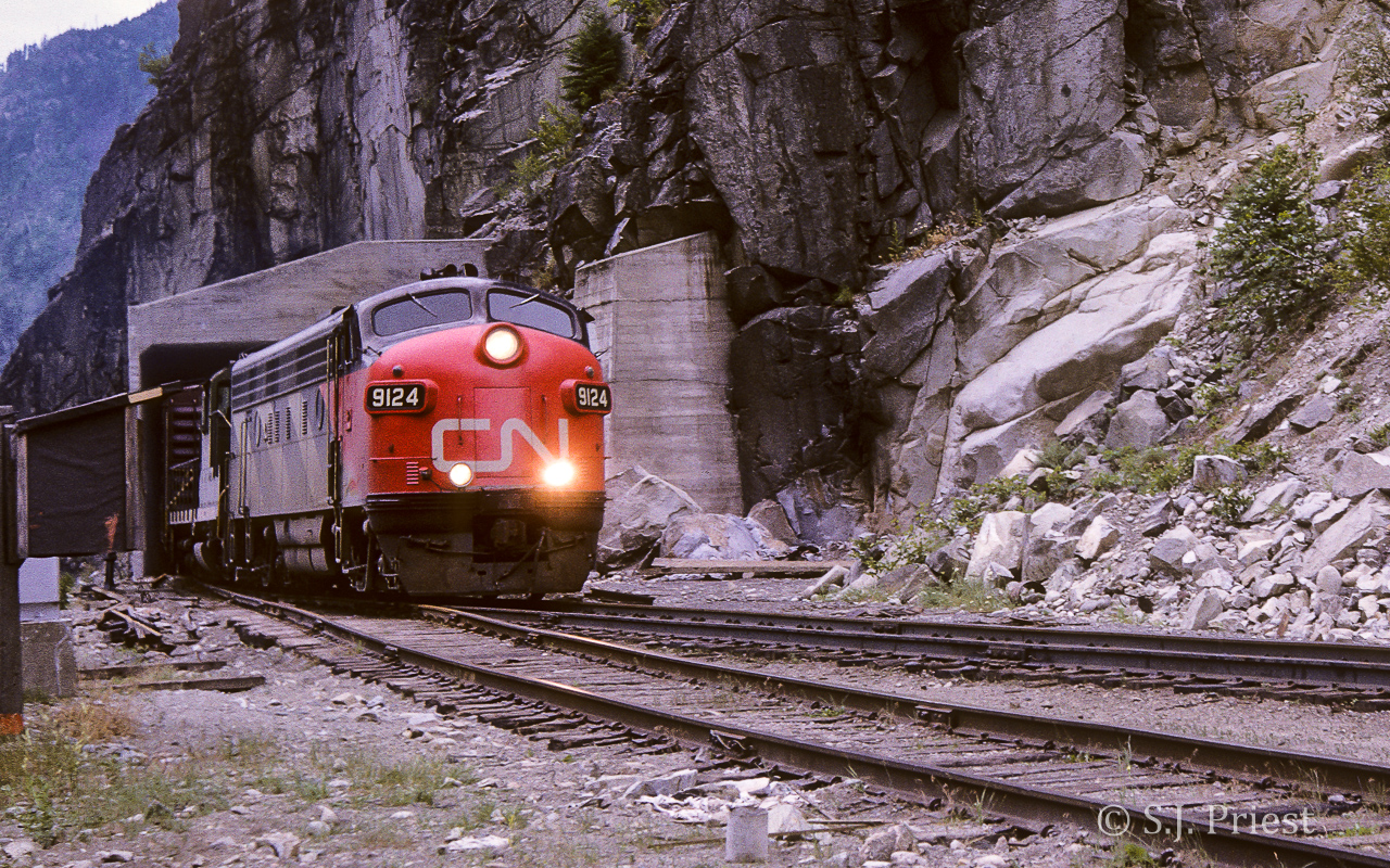 This photo was taken by my Dad in the summer (July?) of 1963 (thank goodness for dates stamped on Kodak slides). The exact location is not firmly known. Hells Gate gives easy access to the tracks from the highway and there is a tunnel entrance located right there. Thus I feel fairly confident that this is the picture location. Looking on Google Earth, there doesn't seem to be any other points offering a Dad an easy route while he leaves the family in the car. The 9124 was built in Nov./52 and 3 years later (March/66) it will be involved in a rock slide wreck. Oddly enough, this wreck was only several miles north of here at Boothroyd. It was retired shortly afterwards.