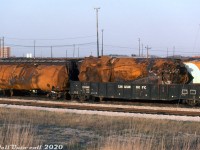 Some of the tank cars involved in the November 10th 1979 Mississauga train derailment sit in CP's Toronto (Agincourt) Yard, presumably kept for inspection during the aftermath investigation. As most know, a tank car on an eastbound CP freight had a hox box that caused a large derailment on the Galt Sub at <a href=http://www.railpictures.ca/?attachment_id=34580><b>Mavis Road grade crossing</b></a> in Mississauga, including some chemical tank cars that derailed and caught fire and/or exploded. A load of leaking chlorine gas in one of them caused mass evacuation of much of the city as fire crews tried to contain the blaze and stop the leak.
<br><br>
Two tank cars in particular are shown here. The wrecked one in CP gondola 333360 appears to be chalked UTLX 29327 or 77 on the bottom. A less-manged one is riding on its own, likely on some shop trucks or spares off the wreck auxiliary train that rerailed it.
<br><br>
<i>Keith Hansen photo, Dan Dell'Unto collection slide.</i>
