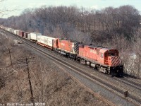 CP C424 4215 leads M636 4704 on train #557 through Bayview Junction, exercising trackage rights over CN's Oakville Sub to Canpa and CP's Obico Yard, with a healthy string of intermodal COFC (Container on Flatcar) traffic including some Tropical 20' cans on the lead flat. The second flatcar in with the trailer appears to be a TTX "Front Runner" 2-axle spine car.<br><br>At the time this was shot the last of CP's big MLW 6-axle fleet had been "officially" retired at the end of 1993, but some units including the trailing M636 had just been reactivated due to a power shortage when CP was scrambling to lease or run anything they could find (including <a href=http://www.railpictures.ca/?attachment_id=38637><b>VIA F40's</b></a> and <a href=http://www.railpictures.ca/?attachment_id=39237><b>rent-a-wrecks</b></a>). The big M's only lasted a year or less until they either failed in service, or were retired a second time. New power started arriving in Fall 1995 in the form of the 9500-series GE AC4400CW's.<br><br><i>Reg Button photo, Dan Dell'Unto collection slide.</i>