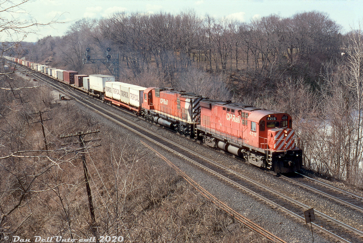 CP C424 4215 leads M636 4704 on train #557 through Bayview Junction, exercising trackage rights over CN's Oakville Sub to Canpa and CP's Obico Yard, with a healthy string of intermodal COFC (Container on Flatcar) traffic including some Tropical 20' cans on the lead flat.

At the time this was shot the last of CP's big MLW 6-axle fleet had been "officially" retired at the end of 1993, but some units including the trailing M636 had just been reactivated due to a power shortage when CP was scrambling to lease or run anything they could find (including VIA F40's and rent-a-wrecks). The big M's only lasted a year or less until they either failed in service, or were retired a second time. New power started arriving in Fall 1995 in the form of the 9500-series GE AC4400CW's.

Reg Button photo, Dan Dell'Unto collection slide.