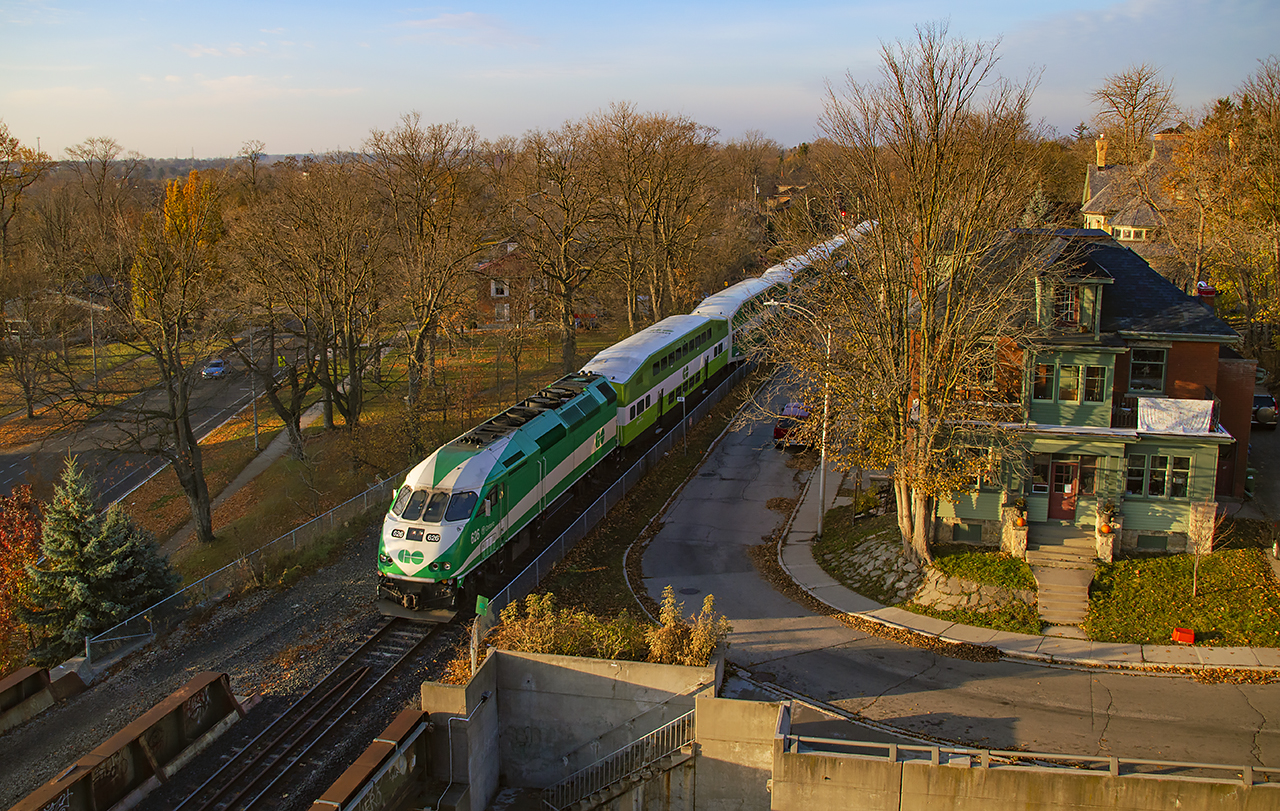 Low November sun brightens the day as train 3806 runs through the heart of Guelph.  Waterloo Avenue can be seen below at left.One of the oldest roads in Guelph, this Waterloo Avenue was once level with the GTR line, and grade crossings (Wilson and Norfolk Streets) existed here.  Grade separation came in 1911, coinciding with the construction of Guelph's new station, and coming after lengthy disagreements between the City of Guelph and the railway, including a lawsuit of public nuisance (Guelph Mercury, November 11, 1908) for lack of a new station, and three grade crossings in the downtown core (the third being Wyndham - then Huskisson - Street).  A later grade separation in 1965 would create the underpass pictured above for Norfolk Street to continue through.As seen in the linked image above, rails once ran down the centre of Waterloo Avenue, then called Market Street for a portion.  This was one of the first lines of the Guelph Railway Company, later Guelph Radial Railway, founded by brewmaster George Sleeman of the Silvercreek Brewery.  This line would also host the railway's car barns at 371 Waterloo Ave. which still stand as apartments today.A complete Inventory of Shop Tools & Car Equipment of Guelph Radial Railway, December 1920 was recently added to the online archives of the Guelph Civic Museum, providing great technical detail for the roster.