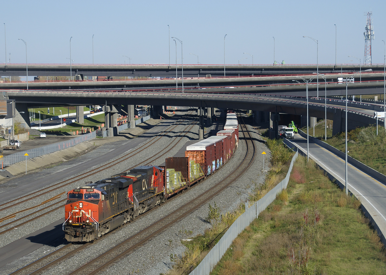 A 113-car CN 527 has CN 2314 & CN 2139 for power as it emerges from the newly reconstructed Turcot interchange on a sunny fall day. Up front are two flatcars with aluminum ingots, a type of commodity not normally seen on this train.