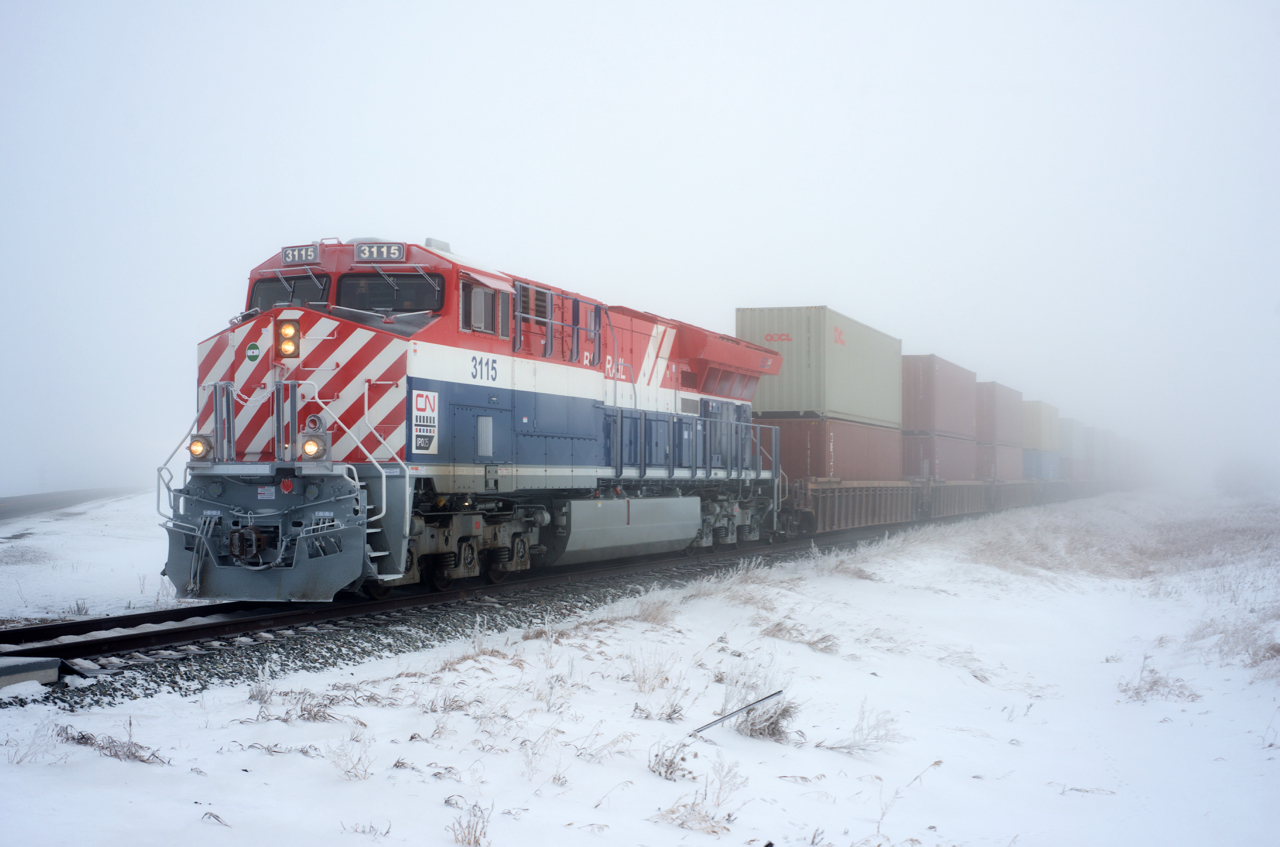 CN 183 pops out of the ice fog just west of Semans Saskatchewan with BC Rail heritage unit 3115 on the point.