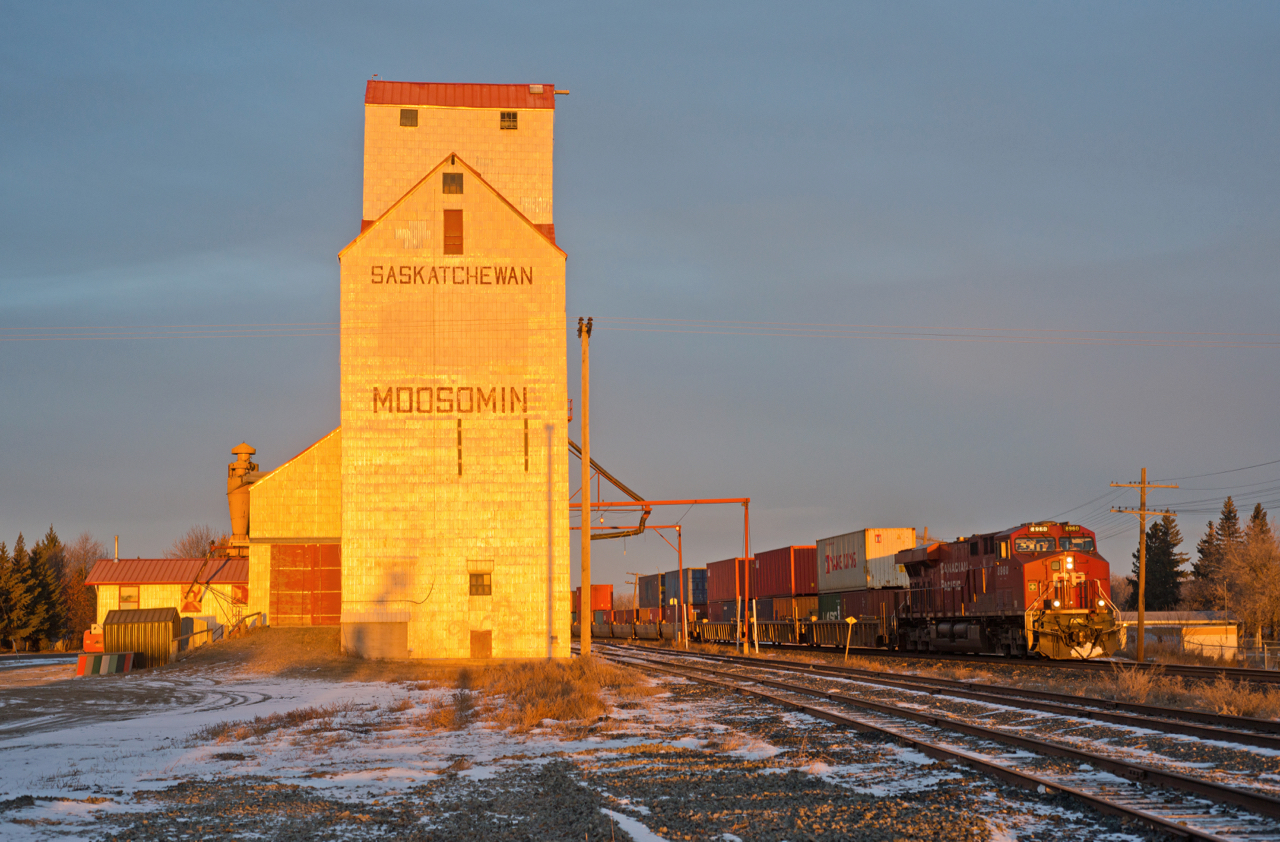 CP 8960 east catches the first rays of daylight as it speeds past the elevator at Moosomin Saskatchewan.