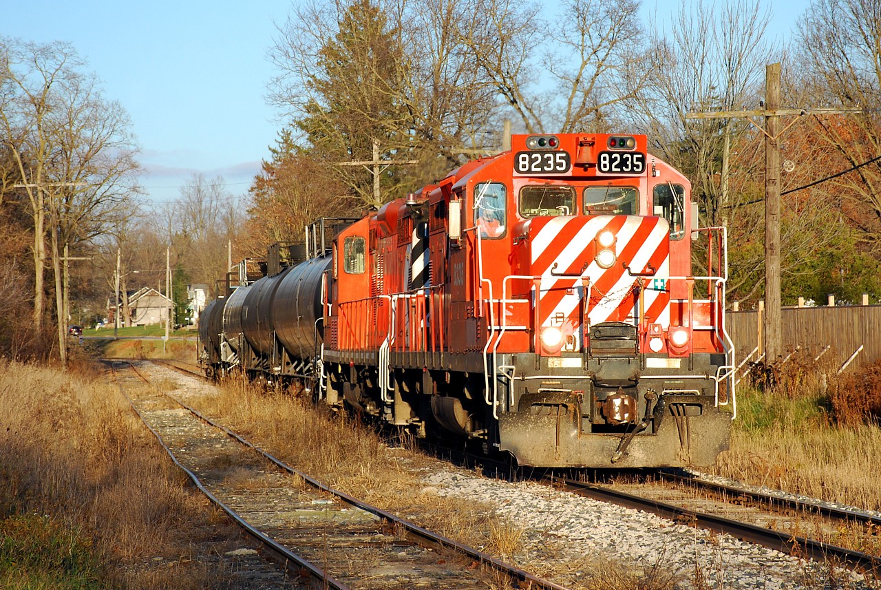 Just like old times.  Looking just like the CP St. Thomas Sub. before Ontario Southland, the OSR Woodstock Job passes by backyards in Beachville, ON in the last light of the day.  It's pretty depressing how early the sun sets this time of year, the photo was taken at 4:10 p.m.!  Today's train had two CP-painted geeps and four tank cars that they had just picked up from CP T69 in Woodstock.    CP T69 went in to emergency around Zorra and it sounded like they had to make repairs to a car, so the OSR crew had an extra long break in the Woodstock station waiting for their cars.