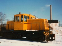 Unnumbered GE Center Cab (likely #4) is back on switching duty shuttling around gondolas of pig iron on the property of the Canadian Furnace Division of the Algoma Steel Corporation.  In the background is the 750' tall INCO (International Nickel) stack in an active role until Electrolytic Nickel production ceased a few years after this photo was taken.  The stack was removed by the mid 90's.  The white brick building in behind was originally the Cronmiller & White Brewery, constructed in 1855 by Jacob North, producing the iconic "Maple Leaf" Beer.  The building still stands today.  The locomotive was on the property from 1949 (new) till 1981, and is now part of the Colorado Railway Museum, Golden Colorado (repainted in black and numbered as - #4), courtesy Paul O'Shell - #4 information.  