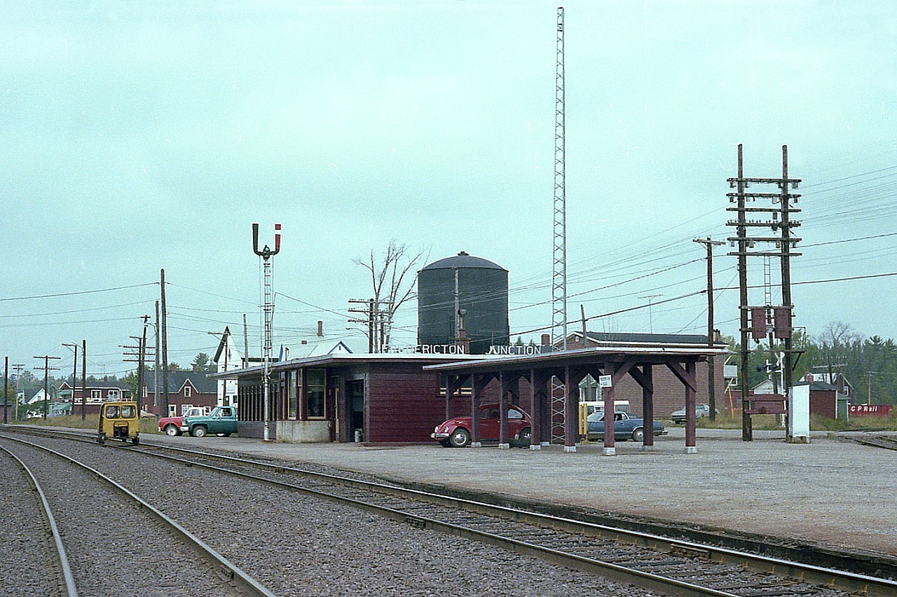 Fredericton Jct is located about 30 miles S of Fredericton, the capital of New Brunswick. It is but a village of about 700 souls, but once was a major player in the history of the province. As well, it was the junction of the European and North American Railway (Vanceboro, Maine to St. John, NB), and the Fredericton Branch Rwy, which ran from the Jct to the Capital.
This old station is still there, although in abbreviated form, car port gone, water tower and signal tower gone, and painted up green for the New Brunswick Southern.