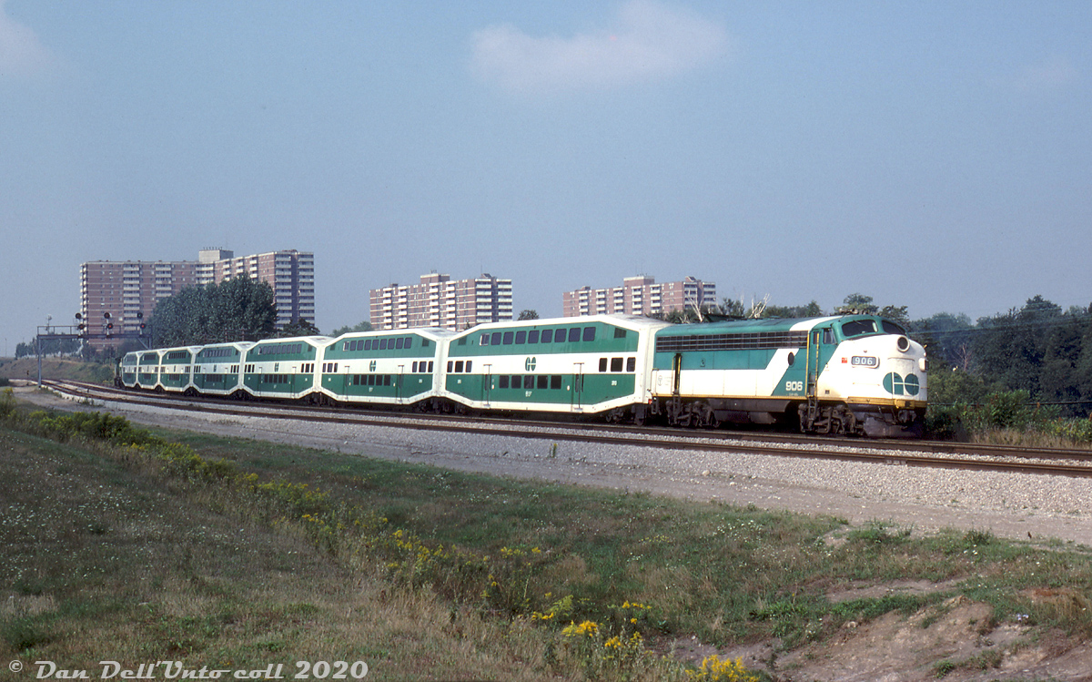 Cruising through the east end of town, GO APCU 906 trails a 7-car train of bilevels and unknown 700-series GP40-2W leader, heading westbound on the CN Kingston Sub at Scarborough Golf Club Road (Mile 322). Apartment buildings off nearby Markham Road are visible in the background.

The new GO 2000-series Hawker Siddeley bilevels had been in service for a little over a year and a half, but since no matching bilevel cab cars were included in the 80-car order and GO ran all its trains in push-pull service, they either needed a locomotive at both ends, an old single level cab car, or an APCU at one end to lead in that direction from.

Dennis Nehrenz photo, Dan Dell'Unto collection slide.