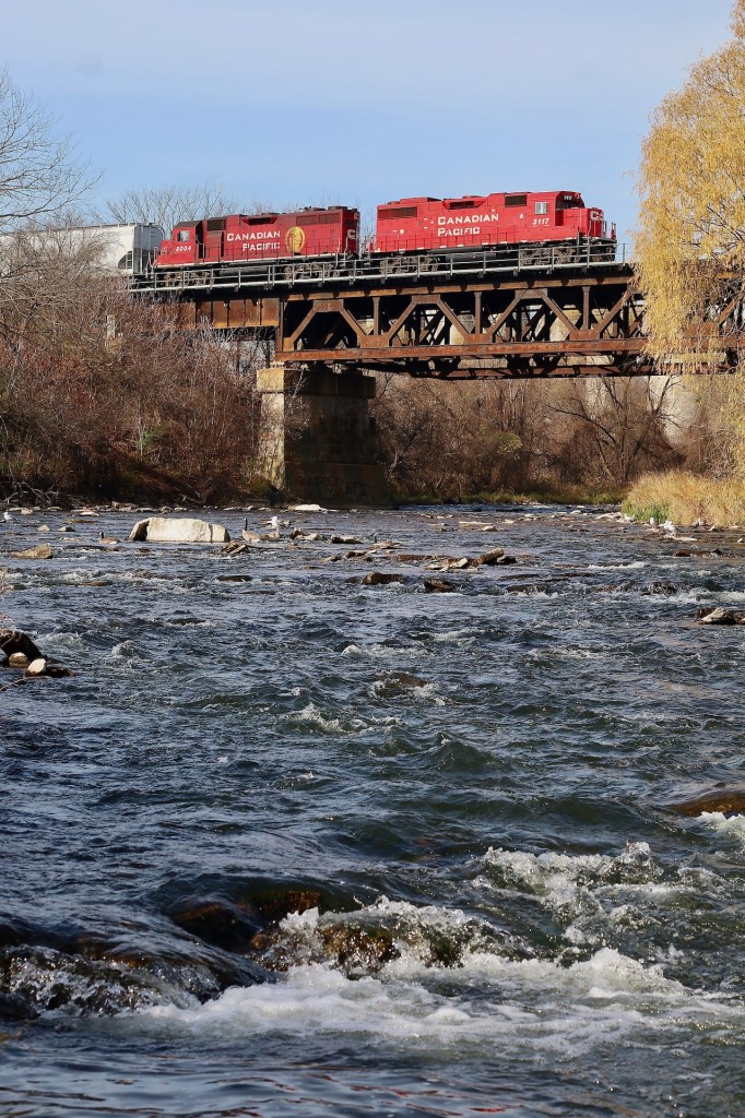 Crossing the river wild. The pungent smell of rotting trout lingers heavy in the air thanks to countless decaying fish along the shoreline of the Credit River. The seagulls definitely don't mind the easy meal though. Overhead CP train T14 with one of CP's youngest and oldest GP38 offerings rattles the old steel bridge as they head back to West Toronto with a stop to switch the CANPA on the way. Trailing GP38AC 3004 has spent most of its life out in western Canada with much of its time spent working the line on Vancouver Island. It even received CP's special E&N green paint for a period. These days its mechanical issues find it coated in oil and never far from Toronto yard in case problems arise.