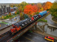 CN L540 departs Guelph for Acton with a huge train in tow. A Red Top Taxi is heading south on Norfolk St, once upon a time this was an at-grade crossing (hard to believe). Fall is in full effect and red-topped trees are at peak colour. The trees is about where <a href=http://www.railpictures.ca/?attachment_id=26586 target=_blank>I photographed this scene</a> in 2016. p.s: while I took this shot a wild Jacob Patterson appeared!