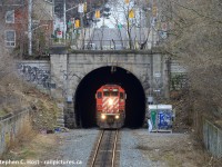 Emerging from the depths of Hamilton's underbelly, SD40-2 5871 with a work train in tow peeks out from the north side of the Hunter St Tunnel. Built in 1895 when the TH&B was permitted to build a line into downtown Hamilton, other than single tracking the once double track CTC mainline not much has changed from this side of the tunnel, aside from the graffiti, litter and other surly things you may find if going for a wander in the grass - here's a hint, don't.


