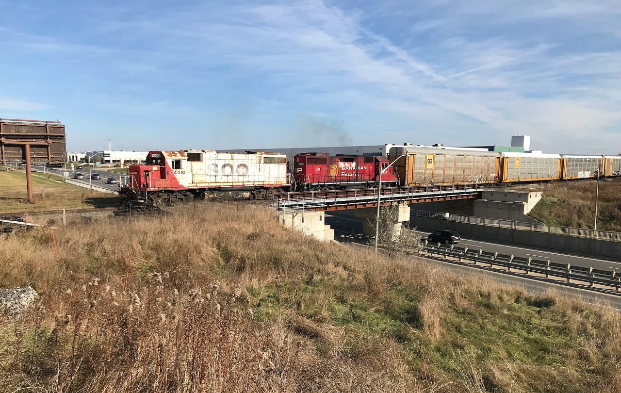 CP T97 with SOO 4410 and 3118 are sorting auto racks for Toyota's Cambridge Assembly plant as they pass over Maple Grove Road in Cambridge, Ontario on the Waterloo Subdivision.