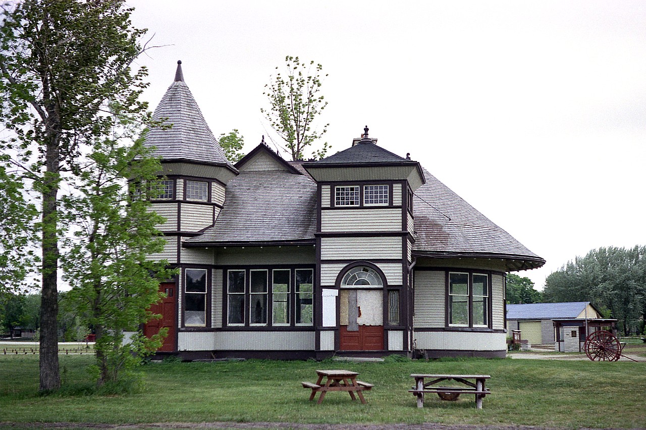 The Grand Trunk extended the original Georgian Bay & Lake Erie Railroad to Wiarton from Owen Sound in 1882. Lot of fanfare that opening day Aug 1st, with a 13 car train and a extensive celebrations. The GTR built a new and improved station in 1904, which is the one pictured. At one point there was also a turntable and roundhouse in town. Roundhouse came down in the 1930s and the turntable was removed in 1961. Passenger service southward was achieved by the train coming out of Owen Sound to the Jct for Wiarton, and backed into town for riders. This service ended in 1957. Freight service ended around 1971 and in 1972 no more trains ran. By 1980 the track was gone. Wiarton station was saved and moved to Bluewater Park near the harbour. Old postcards and photos show an extension that is not seen in this photo. That was the freight shed on the end, dismantled in 1972. The photo here shows the back of the station, the customer entrance, as it was more stylish. In 2004 where the freight attachment was, a new addition was added, (left side in photo) similar in size to the old, but rather open-air and is used as a pavilion.  The town fire hall occupies the location where the station originally stood. The rather unusual structure currently serves as a museum and tourist bureau, and the town takes great pride in their landmark.