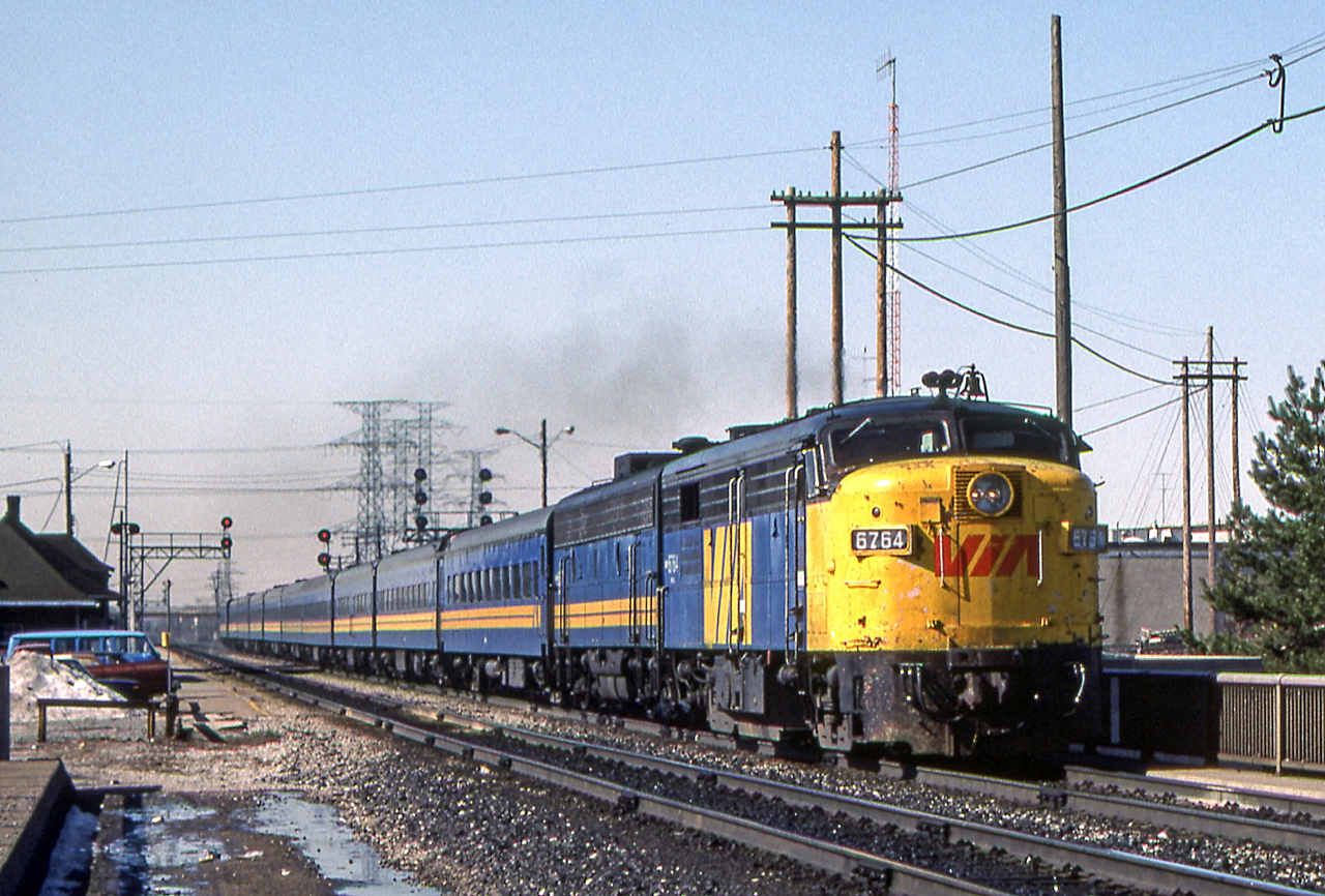 VIA 6764 is accelerating at the VIA station in Burlington, Ontario on March 26, 1984.