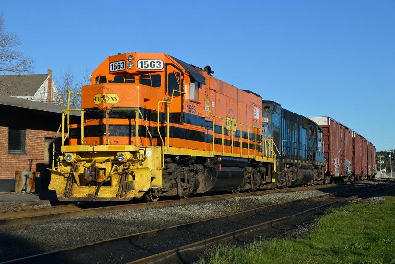 It is late on a warm spring day and CBNS 1563 and 1504 have just finished working industry over at Port Tupper a scant 5 miles away. This scene shows them stopped and perhaps taking a break with paperwork at the old Port Hawkesbury station before moving on to the mainland via the Canso Strait. The 1504, still in LLPX colours, is scheduled to be paint into G&W orange and renumbered 1561.