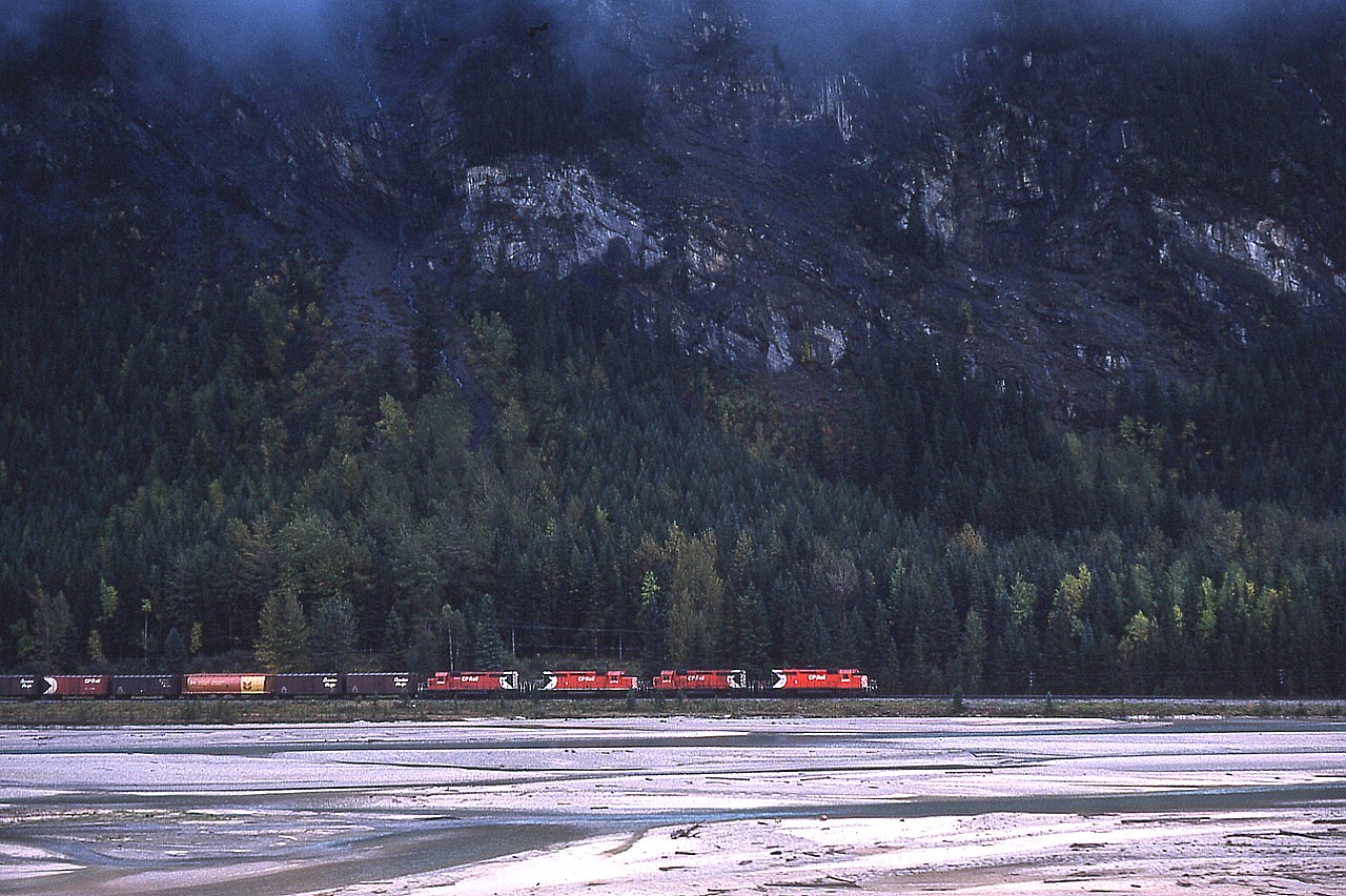 As seen across the Kicking Horse River, a westbound CP with 5520, 5574, 55xx & 5641 works its' way thru the mountainous terrain toward Golden. Shortly, the railroad will duck under Trans-Canada Highway #1, enabling me to have a chance to grab engine numbers.