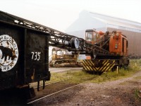 American Rail crane Model 850-80DE Serial J-3414 delivered to Canadian Furnace (Algoma Steel) in 1957 sits idle with Algoma Central Gondola 735.  The rail crane had completed the yard clean up of Victoria Pig Iron and would soon be sent north to ALGOMA STEEL in Sault Ste. Marie.  Gondola 735 is not likely to be found on any rolling stock lists for Algoma Central and was part of the home fleet of in-house cars, some of them labelled as Algoma Central and some as Canadian Furnace. The Casting house is the building in behind and the old school bulldozer lacks the creature comforts of today's "yellow goods".  It would have been used to scrape the pigs that were stuck in ground so the rail bound mag. crane could load them into the gondolas.  Thanks to Paul O'Shell for the rail crane information.  
