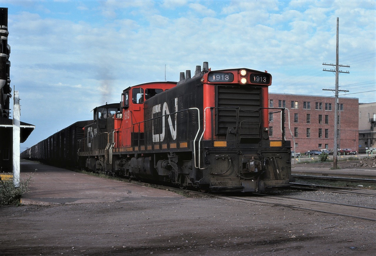 Once equipped with steam generators and 89 mph gearing, these GMD-1s have been downgraded and are now working transfer jobs out of Neebing Yard, Thunder Bay, Ontario.  CN 1913 and 1914 wearing different paint schemes are pulling a large cut of grain cars, most of which are 40 foot box cars.