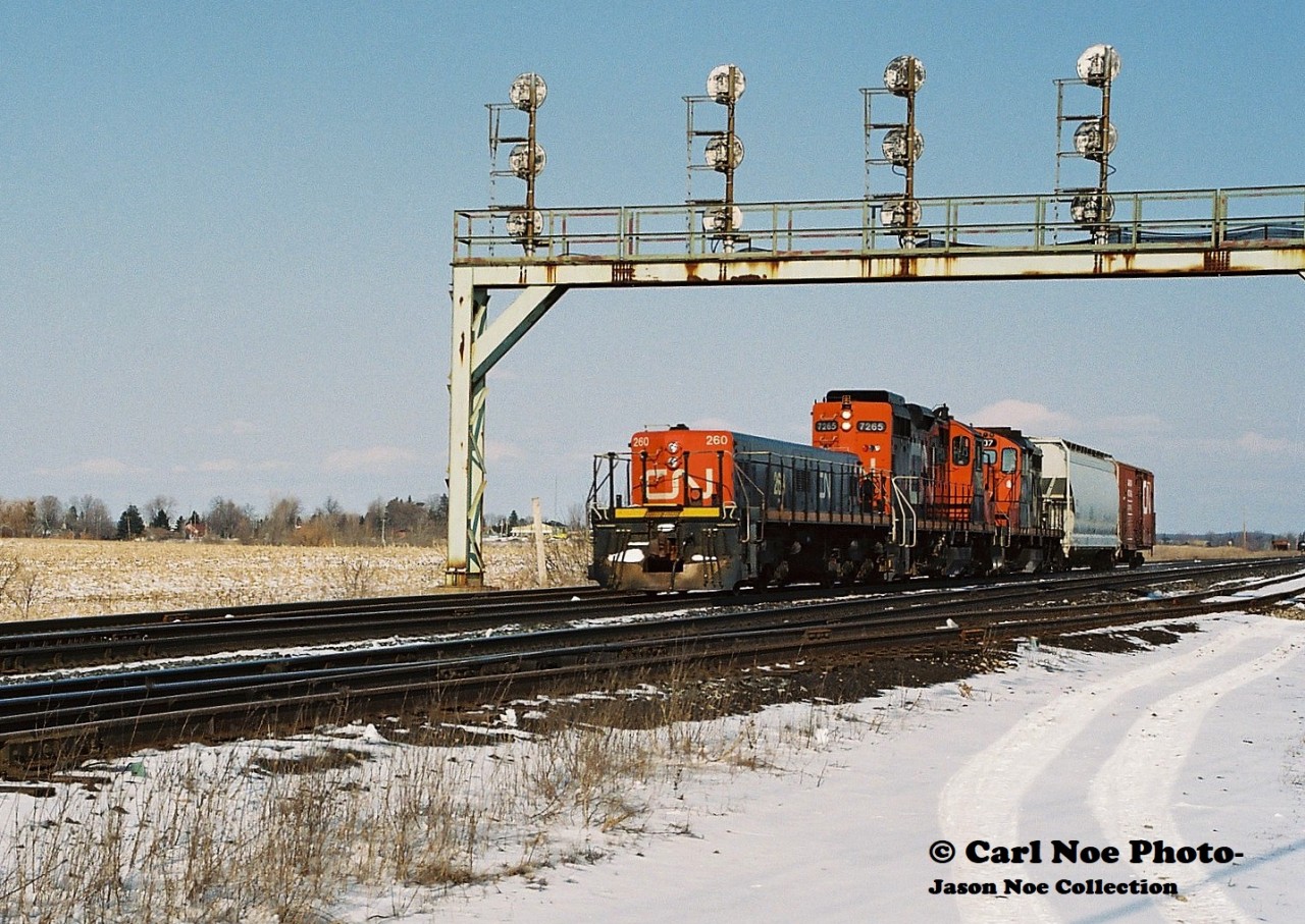 What is assumed to be CN train 585, is viewed departing westbound at Paris West on the CN Dundas Subdivision with CN slug 260 leading GP9RM’s 7265, 4107 and two cars. At the time, this local operated from London as far east as Paris and Brantford, usually making an appearance in the afternoon. CN 260 was classed as an HBU-4, which was a hump booster unit. It wasn’t common practice for a slug set to be assigned to this turn, however it was the 90’s so anything was possible even on local jobs.
