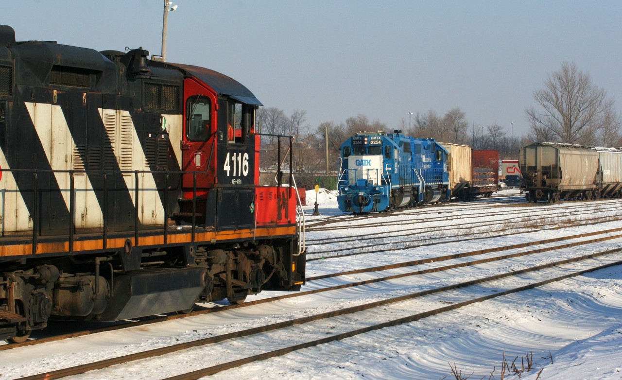 CN L540 with 4116, 4784 and 7025 are passing the Kitchener yard as they return on the siding after coming-up from the Huron Park Spur with a lengthy cut of cars lifted from the CP interchange. In the background CN L568 has just come on duty with a pair of GMTX's. Last year during the weekend's both L540 and L568 would operate, however currently only L568 operates on Saturday-Sunday's.