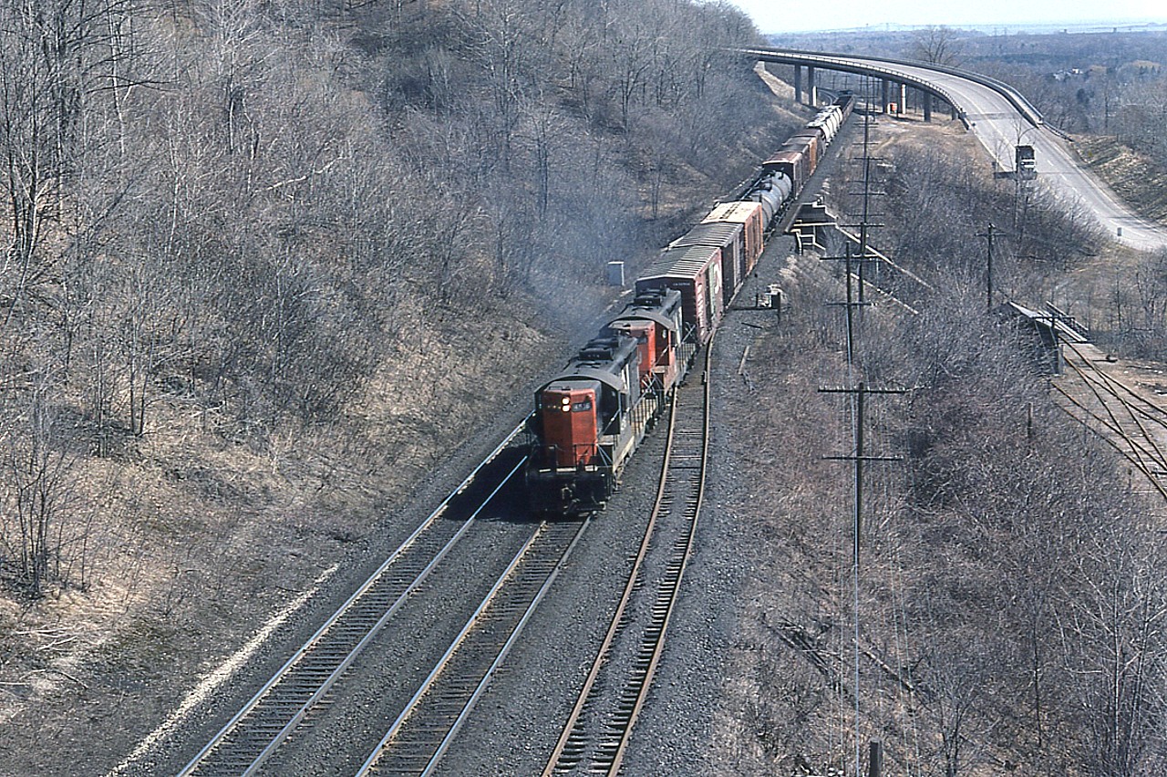 Another old scene as photographed out of that long gone Canada Crushed Stone conveyor overhang above the CN mainline at mile 4, Dundas.  This view is of what I think is the Brantford local out of Hamilton behind CN 4516 and 4565 climbing the grade toward Copetown.  That is the Sydenham Rd bridge background, and the old Steetley operation (dolomite)track at right; now long gone and replaced with a new subdivision of upscale homes.