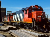 The bi-weekly grain extra was making a stop at the Redwater elevators on a sunny Fall day. The 5516, 5511 and 5592 almost have the cars at their mark as the engineer, with handset out the window, replies an affirmative "half a car". The 5516 looks to have been through the wash rack very recently. The lumber pile in the foreground did disappear over the next year or so. Many of the grade crossings were redone, making a number of them much smoother to negotiate.