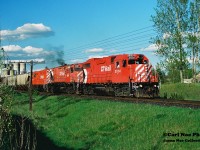 On a pleasent spring evening the CP Hamilton Turn (525) is pictured departing Ayr, Ontario on the Galt Subdivision after lifting 12 hoppers with 3104, 4207 and 8240. The train is approaching the Nith River bridge with 26 cars and is heading west with an eventual meet with 516 at Blandford. 