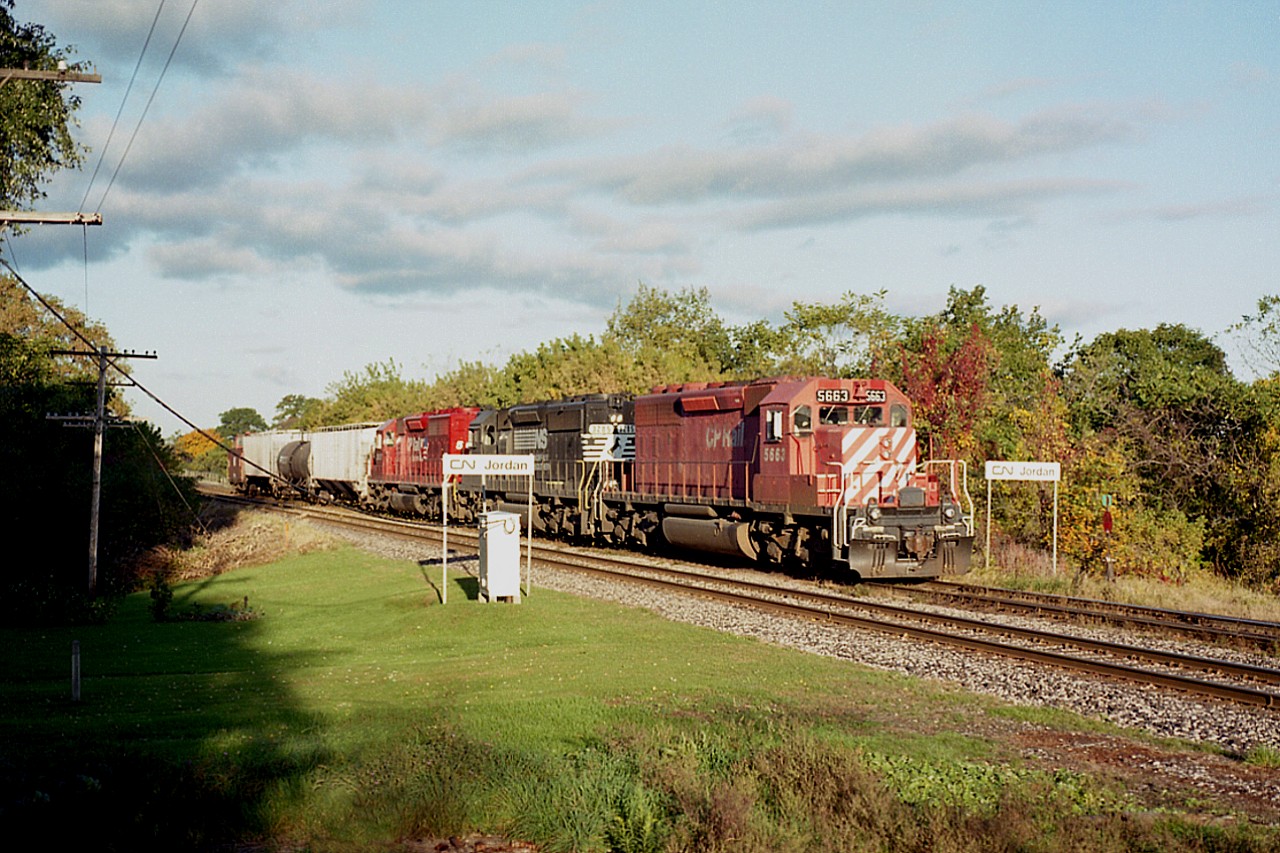 Really nice early morning, as you can see; the sun is around to the south side of the tracks already as the daily NS auto parts train from Talbotville to Buffalo makes its' way thru Jordan. This combination of colour was most often recorded, a CP-NS mix.
Note "Jordan" signs right near where the old station used to be.in the village just west of "7th St. Louth". I was always appreciative of the homeowner that cut grass right up to the tracks. These days, he has either moved on, or gave up.  Power is CP 5669, NS 3285 and CP 5667.