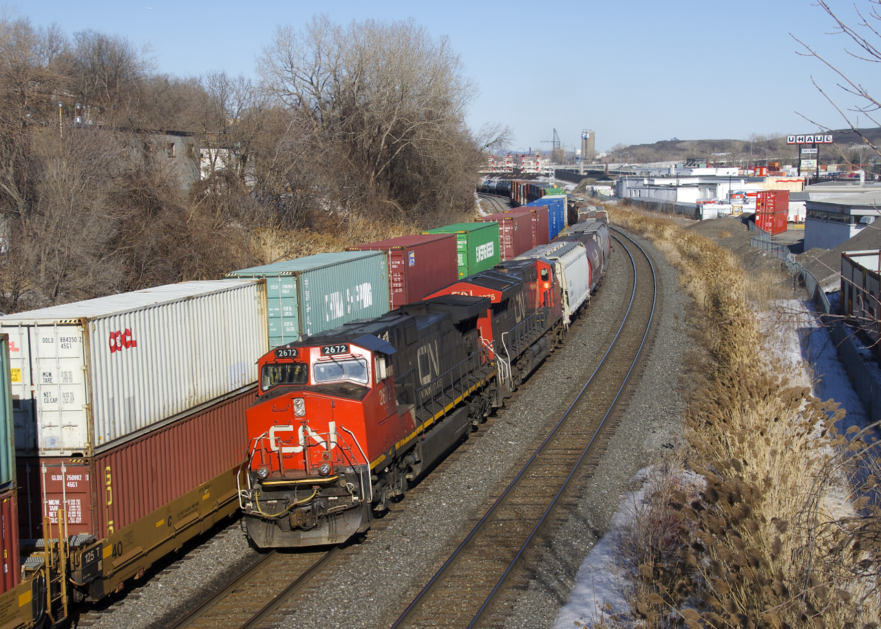 CN 527 with CN 2672 & CN 3075 is slowly passing containers from a CN 108 that is parked on the freight track of CN's Montreal Sub.
