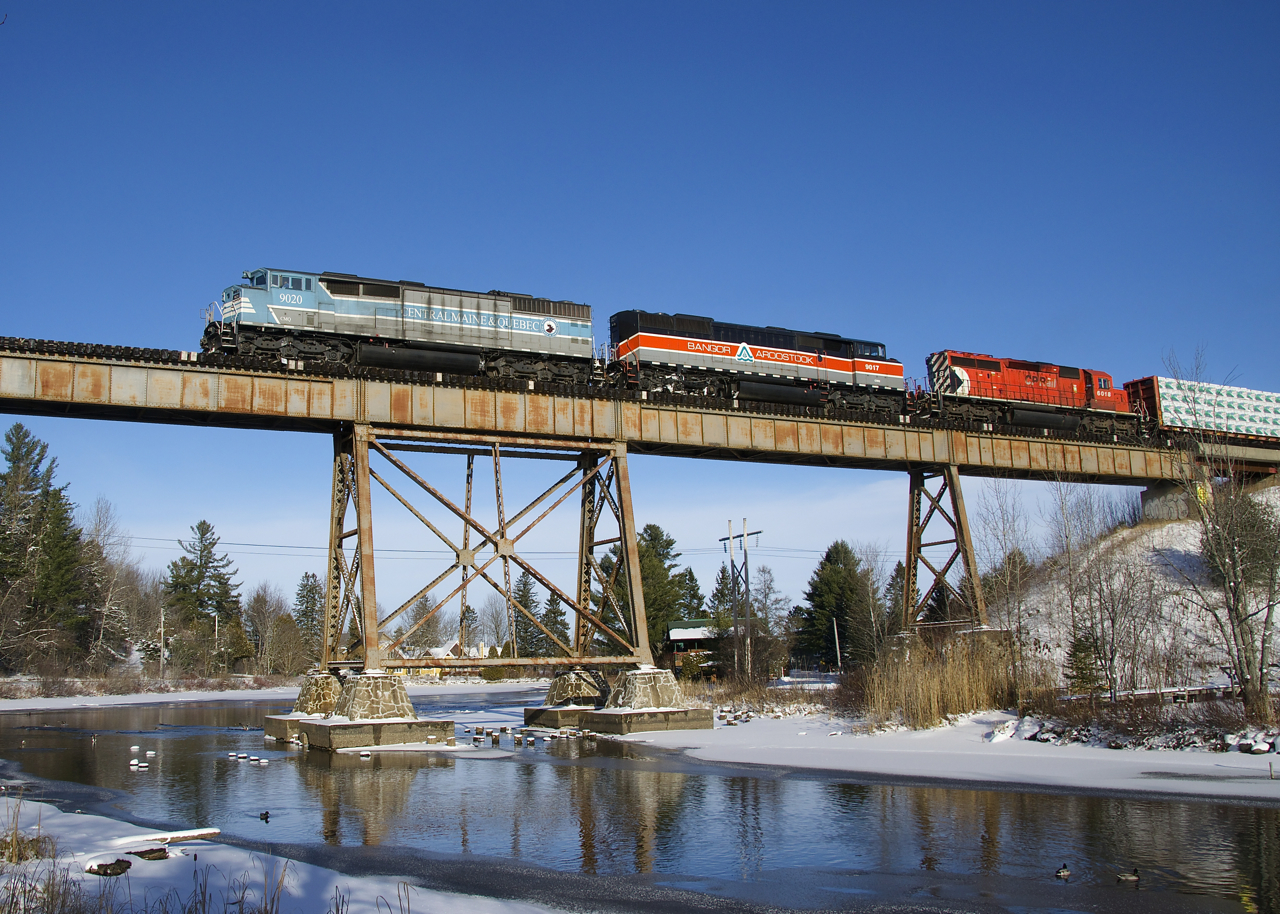 A pair of barns (CMQ 9020 and CMQ 9017) have been on home turf during the past week, going back and forth between Maine on Montreal on CP 250/251. The presence of CP 6018 last though shows that things have changed, with CP now having taken this line back. Here CP 251 crosses the trestle at Eastman with an 81-car train that was taxing the power. A bit earlier they had told the RTC that they were only doing 12-13 mph (track speed here is currently 25 mph).